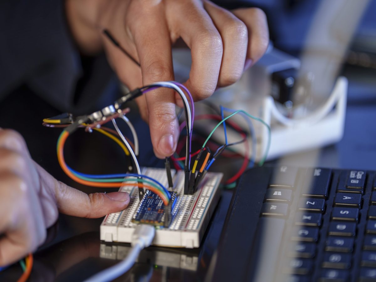 Hands working on a computer and wires