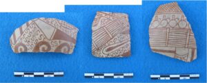 Irregularly shaped fragments of vessel laid on a blue background