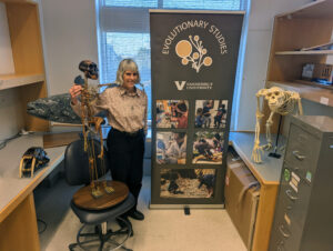 Laura Novick poses with the hominid "Lucy" and other Evolutionary Studies props
